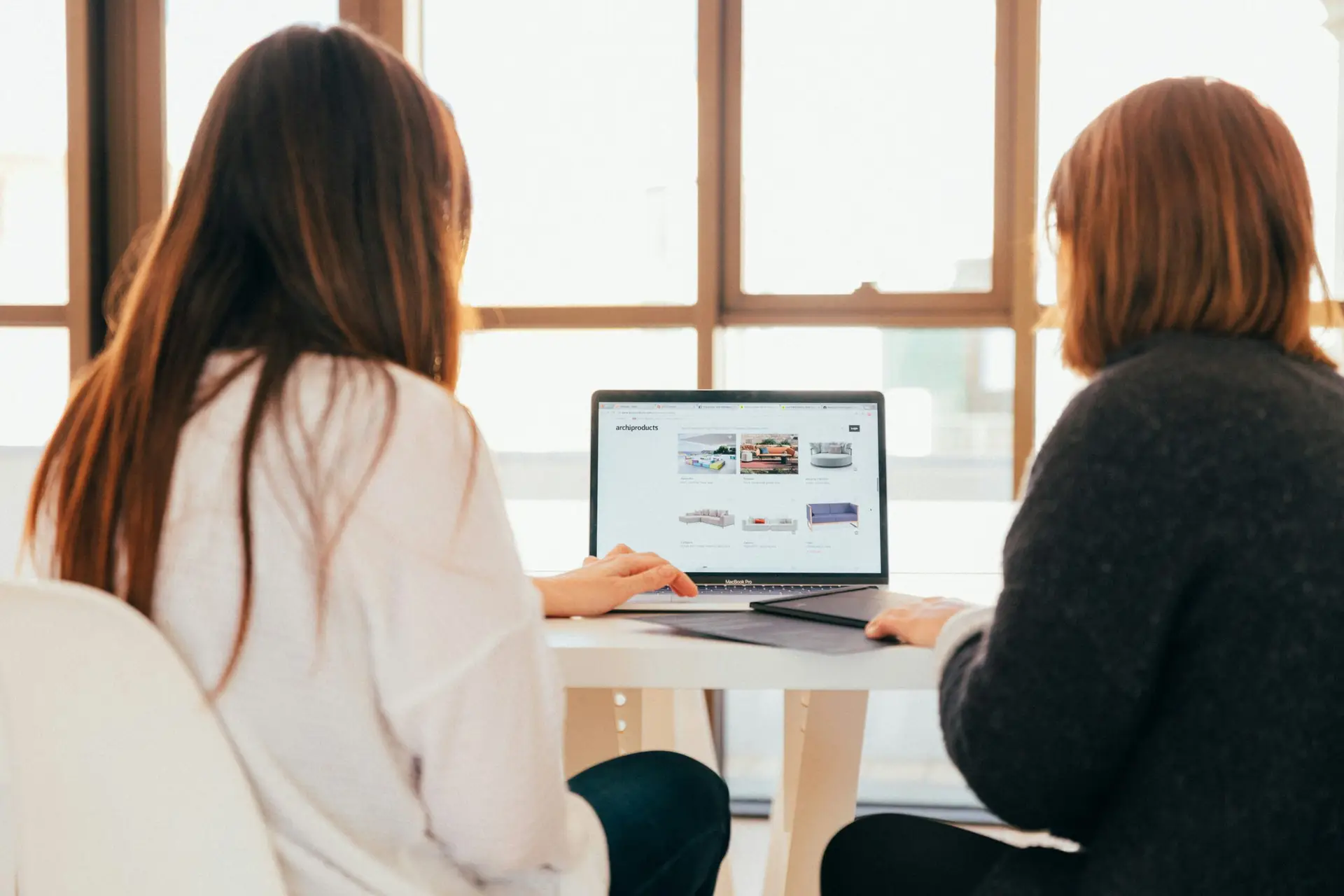 A client and a sales representative sitting together viewing the final design of a website
