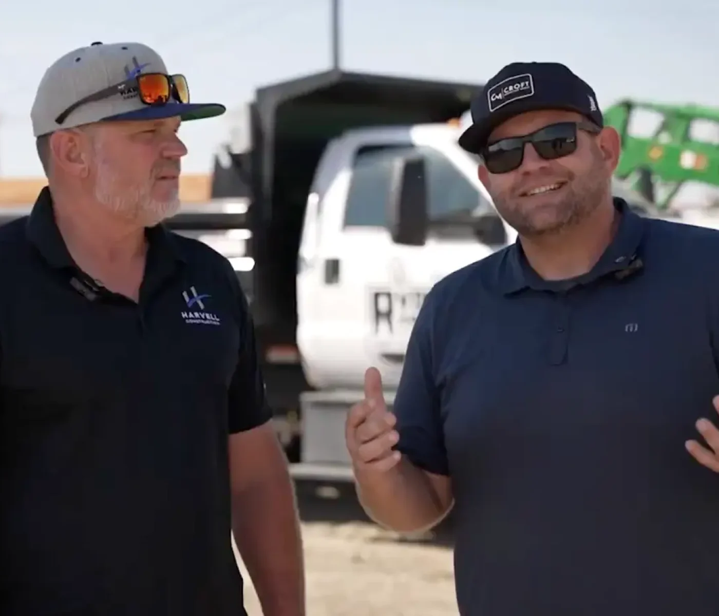 Harvell Founder and CROFT Founder speaking on site with work trucks in background